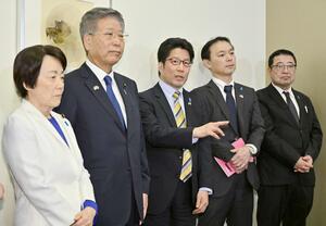 訪米から帰国後、取材に応じる拉致被害者家族会代表の横田拓也さん(中央)と事務局長の飯塚耕一郎さん(右から2人目)ら=4日午後、羽田空港