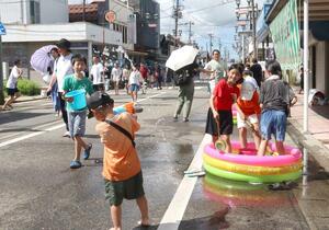 「五泉水かけ祭り」で、互いに水をかけ合って歓声を上げる子どもたち=新潟県五泉市本町2