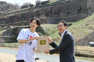 金の盾を持ち、記念撮影する「けえ【島育ち】」さん（左）とゴールデン佐渡の鈴木徹社長＝佐渡市相川北沢町