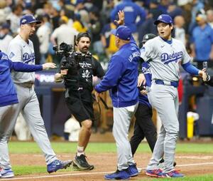 ブルワーズに勝利し、ロバーツ監督とタッチを交わすドジャース・大谷(右)=ミルウォーキー(共同)