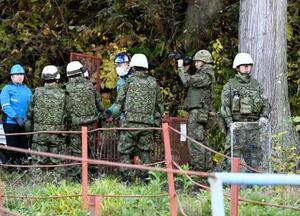 秋田県鹿角市の山林で、周囲を警戒しながらクマ対策の支援活動を行う陸上自衛隊員ら=5日午後