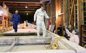 修理見学会で板打ちを実演する松田秀一さん(中央)と息子の和也さん(左)=佐渡市秋津