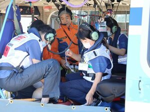 洋上を想定し、プロペラが回る陸上のヘリ内で行った救急訓練=新潟市東区松浜町