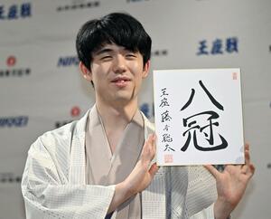 将棋で史上初の全八冠独占を果たし、色紙を手にする藤井聡太新王座=10月11日夜、京都市