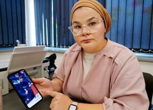 携帯電話に保存した、17歳で亡くなった兄の写真を示すミレラ・オスマノビッチさん=6月、ボスニア・ヘルツェゴビナ東部スレブレニツァ近郊(共同)