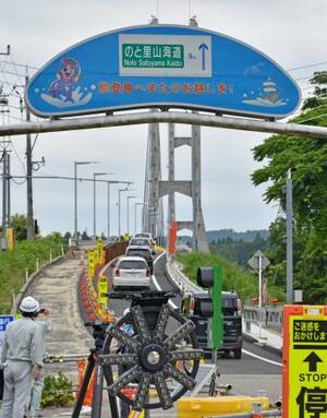 通行可能になった橋「ツインブリッジのと」に向かう車=16日午後、石川県七尾市