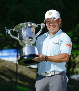 　通算９アンダーで優勝し、トロフィーを手に笑顔の藤本佳則＝茨木ＣＣ
