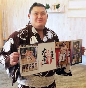 自身の横綱昇進を記念した「フレーム切手セット」を持つ大の里=7日、愛知県安城市の二所ノ関部屋宿舎