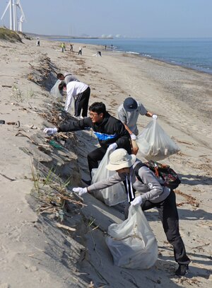 プラスチックや流木などさまざまなごみを拾った海岸清掃の参加者たち=胎内市村松浜