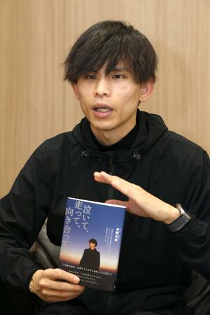 糖尿病の体験や日本一周の旅での出会いなどをつづった著書を紹介する本間太希さん=新潟市中央区万代3
