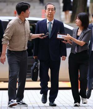 　２７日、ソウル中央地裁に到着した韓悳洙前首相（中央）（聯合＝共同）