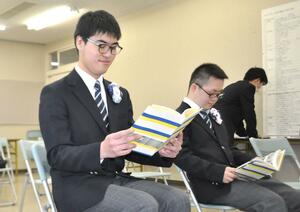 手作りした塩沢紬が帯で巻かれた卒業アルバムを眺める卒業生=南魚沼市西泉田の市立総合支援学校