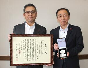優秀企業賞の表彰状を持つホリカフーズの五十嵐一也社長(左)と星正弘専務=魚沼市堀之内