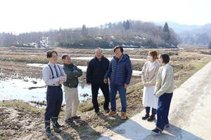 田んぼオーナーを受け入れる「夢ビレッジ胎内２９０」のメンバーら＝胎内市鍬江