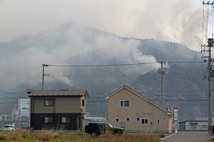 　火災で煙が上がる岩手県大槌町の山林＝２４日午前