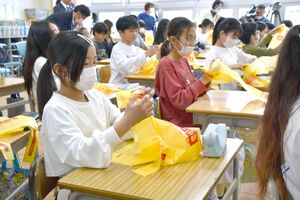 米を原料とする新しいごみ袋を触る児童=新潟市西蒲区の潟東小学校