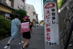 　大阪府豊中市の小学校に通う児童に付き添うヘルパーの東徳子さん（左）＝９月