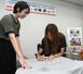 Ｔシャツにサインを書く小海遥選手＝８月２６日、妙高市役所