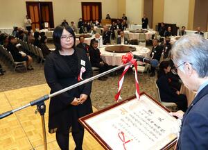 芸展授賞式で賞状を受け取る洋画部門連盟大賞の小飯田亜海さん=11月17日、新潟市中央区