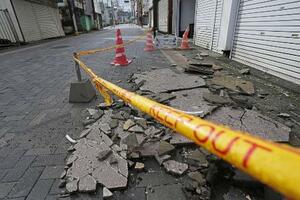　地震で崩れ、道路に散乱した建物の外壁＝２７日午前、山梨県富士吉田市