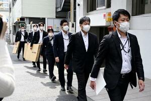 　東亜建設工業横浜支店の家宅捜索に向かう神奈川県警の捜査員＝１４日、午前１０時２分、横浜市中区