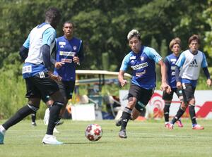 試合に向けて集中を高めるMFシマブクカズヨシ(中央)ら=聖籠町