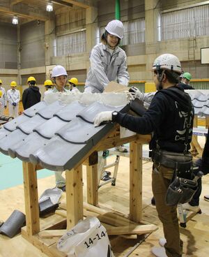瓦ぶきに挑戦する新潟職業能力開発短期大学校の学生ら=新発田市新富町1