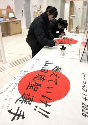 冨田せなさんと山田琉聖さんへの応援メッセージを寄せ書きする中学生＝２９日、妙高市のまちなか＋