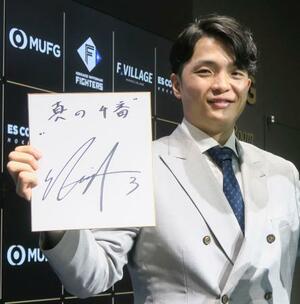 　契約更改交渉を終えて色紙を手にポーズをとる日本ハム・郡司＝３日、エスコンフィールド北海道