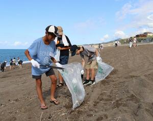 ごみを拾い集める大潟町小の児童ら=上越市大潟区