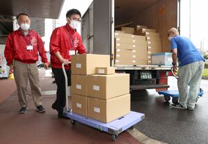 投票用紙の入った段ボール箱を運ぶ市職員ら=27日、新潟市東区