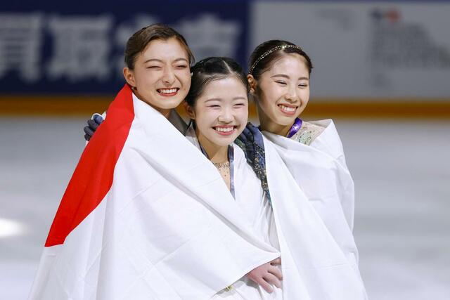 グランプリシリーズ初出場優勝を果たした中井亜美。左は２位の坂本花織、右は３位の住吉りをん＝アンジェ（共同）