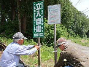 十日町市松之山地域で、野鳥カメラマンの立ち入り自粛を呼びかける看板を設置する愛護会のメンバー