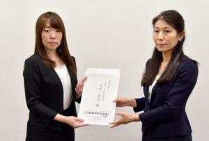 厚労省担当者(右)に要望書を手渡す広島県の北原加奈子健康福祉局長=17日午後、厚労省