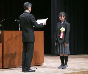 税をテーマにした作文で表彰状を受け取る受賞者=佐渡市中原