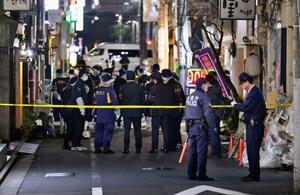 赤ちゃんの頭部のようなものが見つかった現場の雑居ビル付近に集まる警視庁の捜査員ら=6日午後11時51分、東京都墨田区