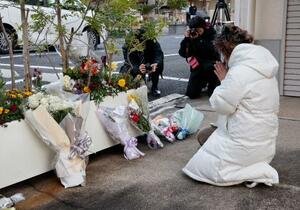 　王将フードサービス本社前で手を合わせる遺族の大東真弓さん＝１９日朝、京都市山科区