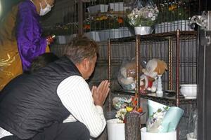 関越道バス事故から14年となり、献花台の前で手を合わせる遺族=29日午前4時40分、群馬県藤岡市
