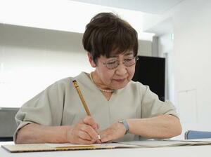 　原爆死没者名簿に名前を書き加える森田孝子さん＝１日午前、長崎市役所
