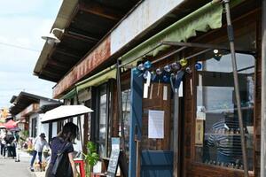青果市場だった長屋を改装した「沼垂テラス商店街」の店舗。旧店舗の看板が昭和レトロな雰囲気を醸し出す=2025年7月、新潟市