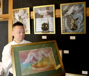 一筆龍の作品を紹介する「数寄屋風雷」の梅田司さん=1月16日、新潟市西蒲区六分
