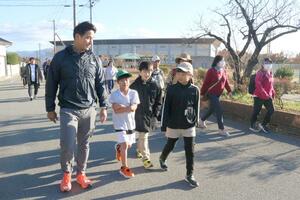 松田丈志さんと一緒にウオーキングを楽しむ参加者=佐渡市