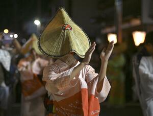 「おわら風の盆」で編みがさをかぶって優雅に舞う女性=2023年9月、富山市