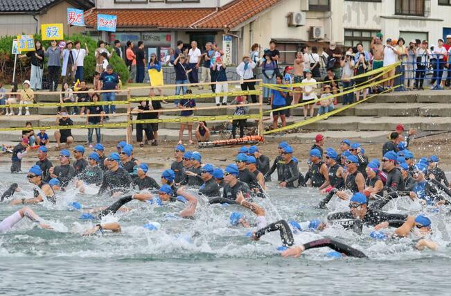 スイムで勢いよくスタートする選手たち＝９月１日、佐渡市