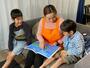 子どもに絵本を読み聞かせするピナイのスタッフ（提供写真）