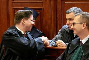 　ドイツへの移送を認めない裁判所の判断を受け、弁護士と握手する「ノルドストリーム」破壊事件の容疑者（右奥）＝１７日、ワルシャワ（ロイター＝共同）