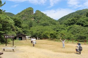 佐渡金山のシンボル「道遊の割戸」と、記念撮影を楽しむ観光客=7月26日、佐渡市相川地区