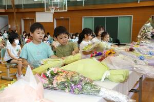 隣接する京田幼児園(当時)の園児3人が亡くなった京田小学校で開かれた追悼式典。児童らが出席し、祭壇に花を手向けた=6月14日、山形県鶴岡市