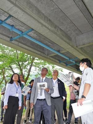橋梁点検と補修について、南魚沼市職員から説明を受けるマダガスカルからの研修視察団=5月24日、新潟県南魚沼市大木六