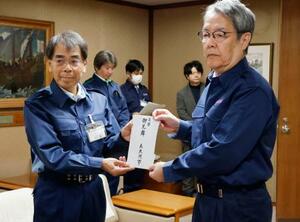 　大分市の佐藤耕三副市長（右）に見舞金を手渡す新潟県糸魚川市の井川賢一副市長＝２９日午前、大分市役所